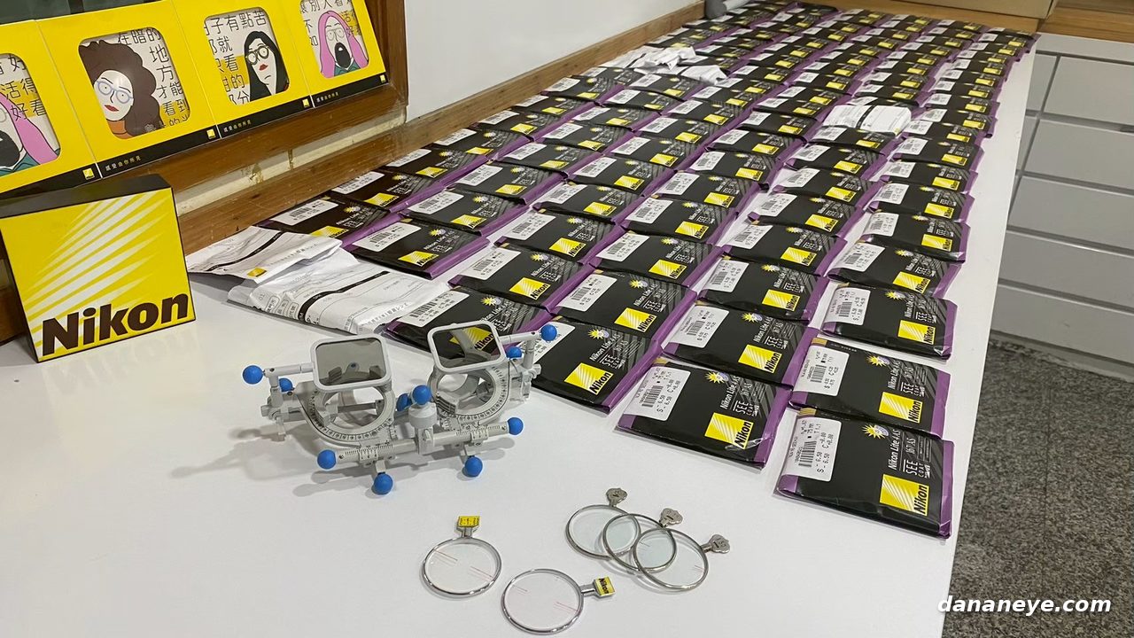 上千片 Nikon 鏡片依序排開在桌上，旁邊是試鏡架與已完成的單片試片
