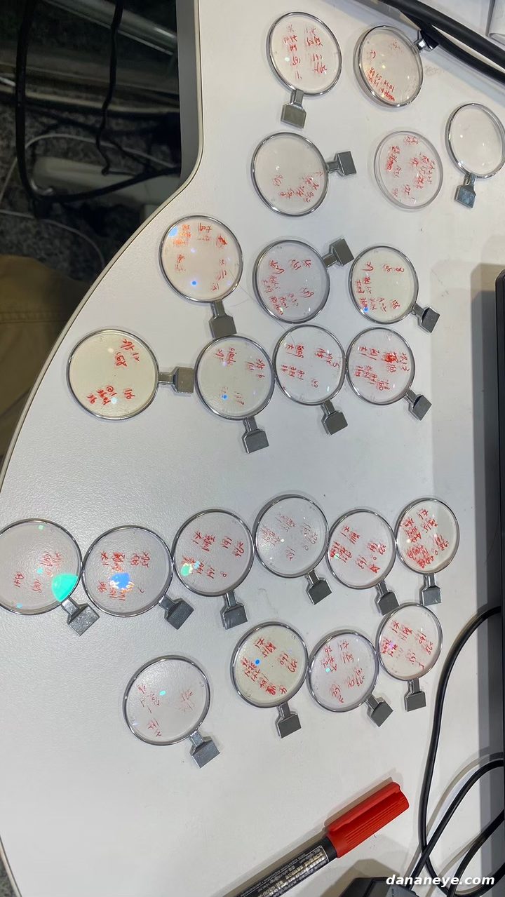 桌上一片一片標有紅色記號的試片鏡片，製作校正過程