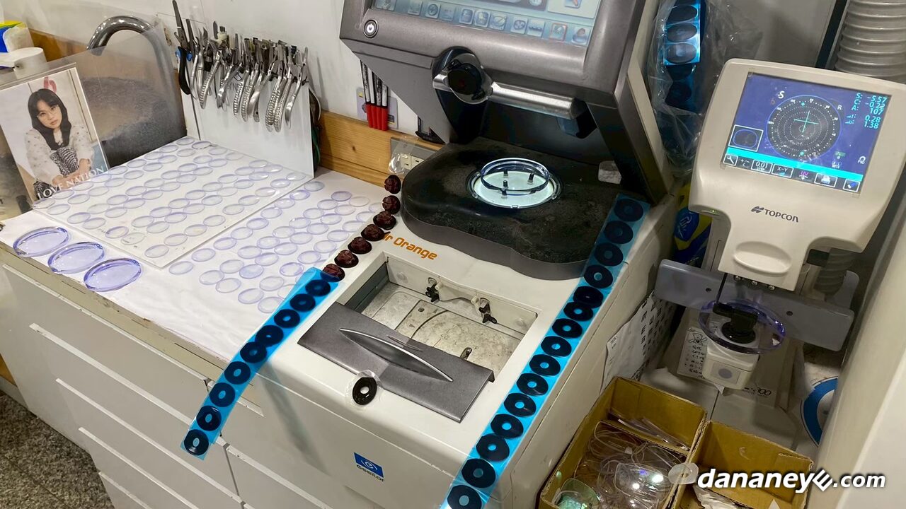 店內的磨邊與製作區,桌面排著鏡片,旁邊是磨邊機與量測儀器 店內的磨邊與製作區,桌面排著鏡片,旁邊是磨邊機與量測儀器