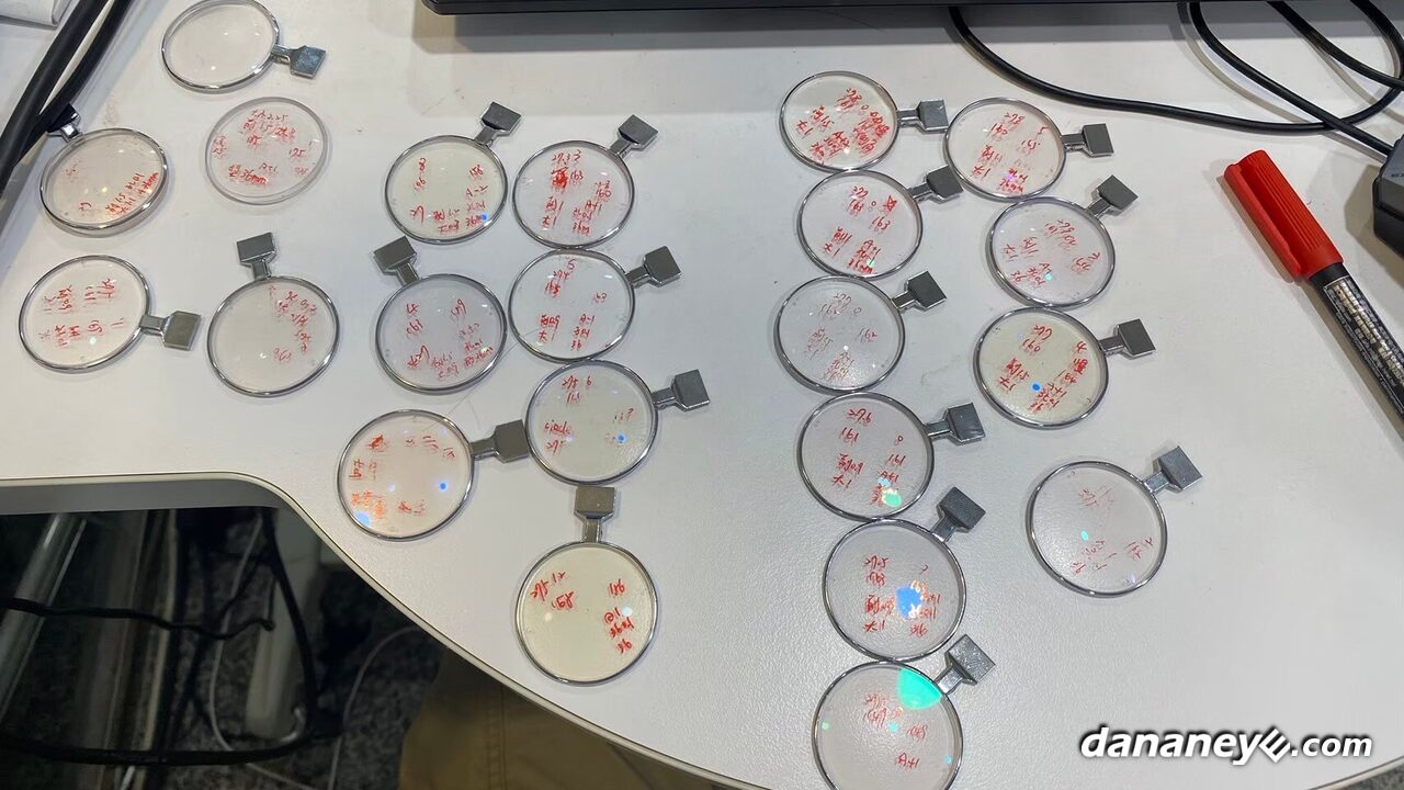 桌上一片一片標有紅色記號的試片鏡片,製作校正過程 桌上一片一片標有紅色記號的試片鏡片,製作校正過程